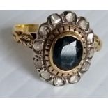 A 19th century oval sapphire and diamond cluster ring in a yellow and white gold basket setting (