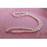 A string of graduated freshwater pearls on a silver clasp, 46 cm