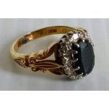 A Victorian oval sapphire and diamond cluster ring, (sapphire 9mm x 6mm approx) stamped 18ct, size