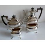 An Edwardian silver four-piece tea and coffee service with wavy rim borders, pearwood handles on