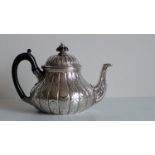 A Victorian silver teapot of baluster form with profusely embossed lobed decoration in the