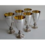 A set of six contemporary conical silver goblets with gilt interiors, cast Celtic-knot and ram's