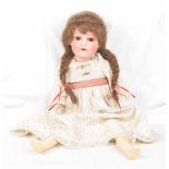 A German bisque headed doll by Heubach & Koppelsdorf With a long auburn wig, open / shut brown eyes,