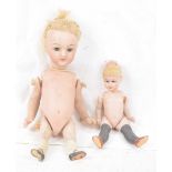 Two small bisque dolls One with blonde wig, fixed brown eyes, painted socks and shoes, height 14cm,