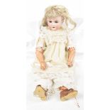 A German bisque headed doll by Armand Marseille With blond wig, open / shut brown eyes,