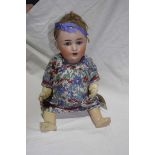 A German bisque headed doll With trimmed auburn wig open/shut blue eyes, open mouth,