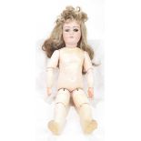 A bisque headed doll With long brown wig, one fixed blue eye,