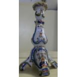 A French faience candlestick, decorated with floral sprays.
