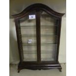 A small arched top glazed display cabinet.