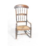 An early 19th Century stained beechwood kitchen rocking chair Having a concave arched top rail