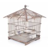 A Japanese wooden birdcage The delicate carved wooden cage, with blue and white porcelain feeds,
