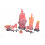 A collection of decorative Chinese simulated amber figures To include a figure of Guanyin,