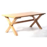 An attractive pitch pine refectory table The rectangular slab top supported on two X shaped