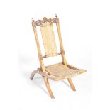A Victorian stained beech and rattan folding child's chair With a pair of turned finials flanking a