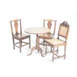 A pair of 18th Century oak chairs and a tripod table The chairs with a vase shaped splat above a