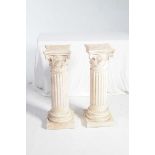 A pair of painted plaster columns, late 20the Century The 82cm high columns with Corinthian tops.