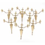 A set of eight early 20th Century Adams style wall mounted brass light fittings Each cast with a