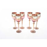 Set of six pale cranberry and gilded wine glasses,