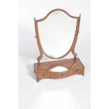 A 19th Century mahogany shield shaped toilet mirror With a bevelled plate raised on tapering