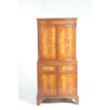 A Georgian style mahogany serpentine drinks cabinet by Reprodux With two flame mahogany doors above