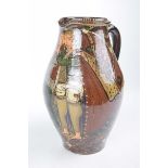 An unusual glazed studio pottery jug The treacle glazed jug painted with two figures embracing,