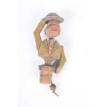 A novelty figural carved wooden bottle stopper In the form of a gentleman wearing a hat with a pull