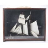 A cased diorama of a two masted sailing ship,