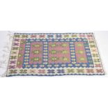 A blue ground Kilim style rug The tasselled rug with woven geometric design set within borders