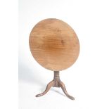 A Georgian mahogany tripod table The circular top supported on a ring turned shaft,