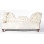 A Victorian twin arch settee With a twin arch button back above a serpentine seat raised upon