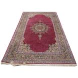 A Tabriz style carpet The red and ivory coloured ground, with tasselled edges,