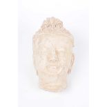 A carved stone head fragment of Buddha The well carved face with downcast eyes and high Ushnisha,