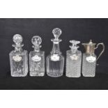 Four assorted glass decanters and a claret jug,