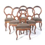 A set of six Victorian walnut balloon back dining chairs The balloon backs carved with a flower