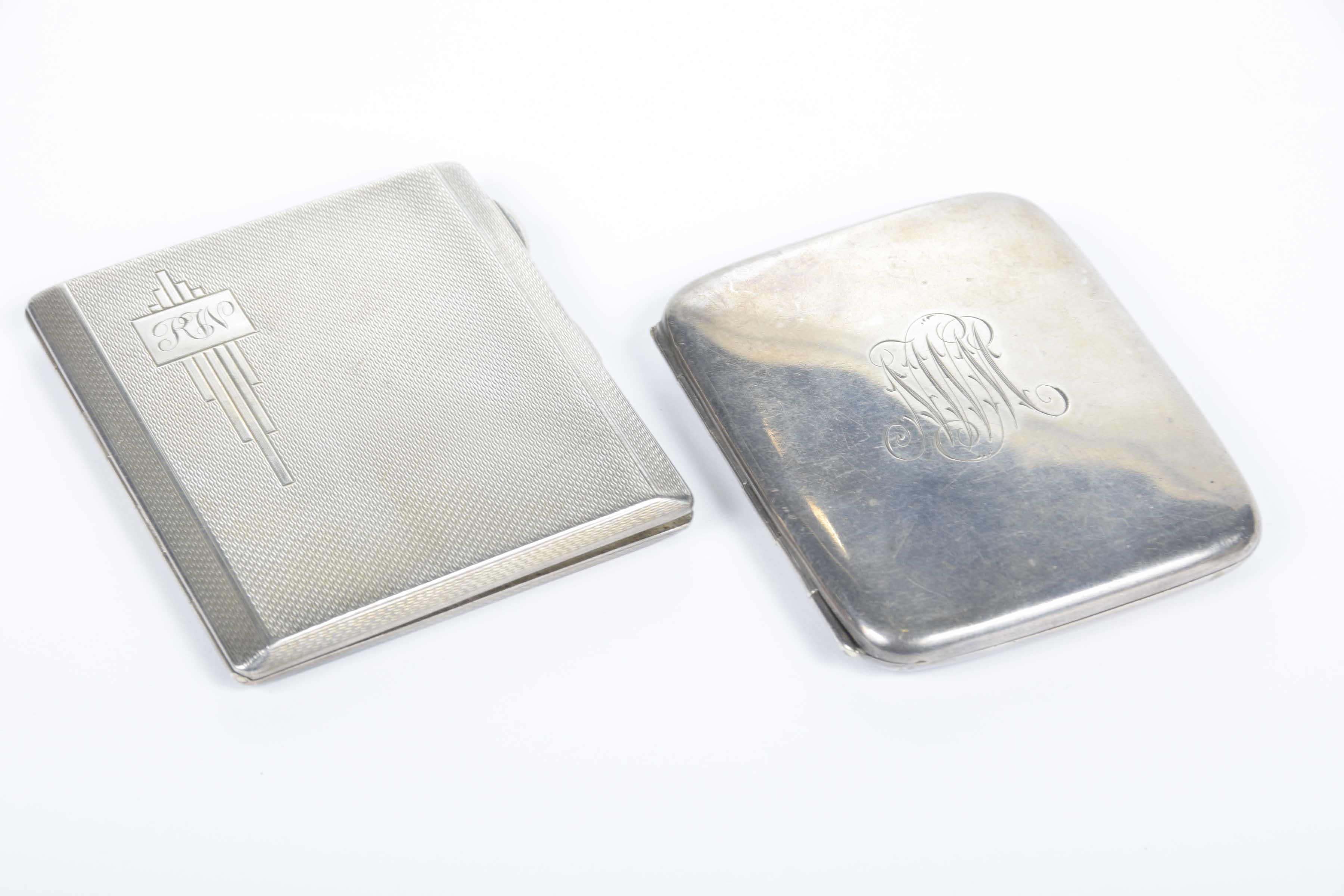 Two silver cigarette cases One of rounded form, centred with initials,