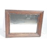 A large carved South East Asian wall mirror The carved hardwood frame with a series of geometric