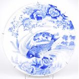 A Japanese Arita porcelain 'Carp' charger The large circular dish, with shallow well,