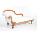 A Victorian mahogany framed chaise lounge With an arched padded and button back and a conforming