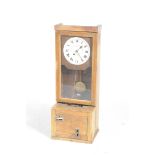 A 1930 oak cased Gledhill-Brook time recorder The punch time clock with a glazed door enclosing a