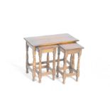 A nest of three reproduction oak tea tables The largest rectangular top on turned supports with two