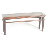 A Chinese Huanghuali style low bench The planked top within mitred edging,