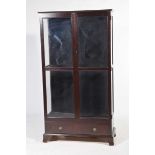 A modern mahogany effect free standing display cabinet Having two glazed doors enclosing two