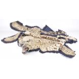A leopard skin rug, circa 1920/30s The rug with head, complete with glass eyes, teeth,