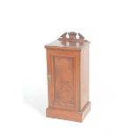 A late Victorian walnut pot cupboard The rectangular top with a architectural pediment above a