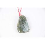 A Chinese green hardstone pebble pendant The variegated green hardstone pendant depicting two