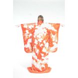 A Japanese embroidered kimono, 20th Century The vibrant red/orange fabric,