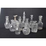 A collection of approximately eleven cut glass wine decanters,