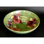 A Walter Moorcroft bowl of circular form Decorated in the 'Orchid' pattern on a green ground,