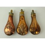 Three copper and brass powder flasks mid 19th Century First with fluted bodied decoration,