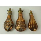 Three copper and brass powder flask mid 19th Century The first decorated with 'Pharoahs Horses',